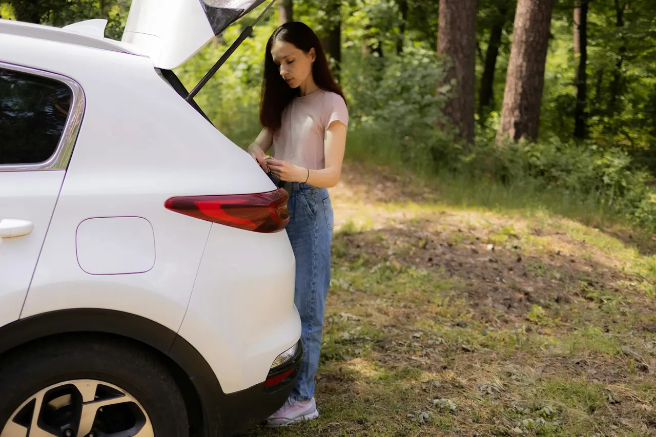 Mulher arrumando o porta-malas do carro para um passeio no bosque