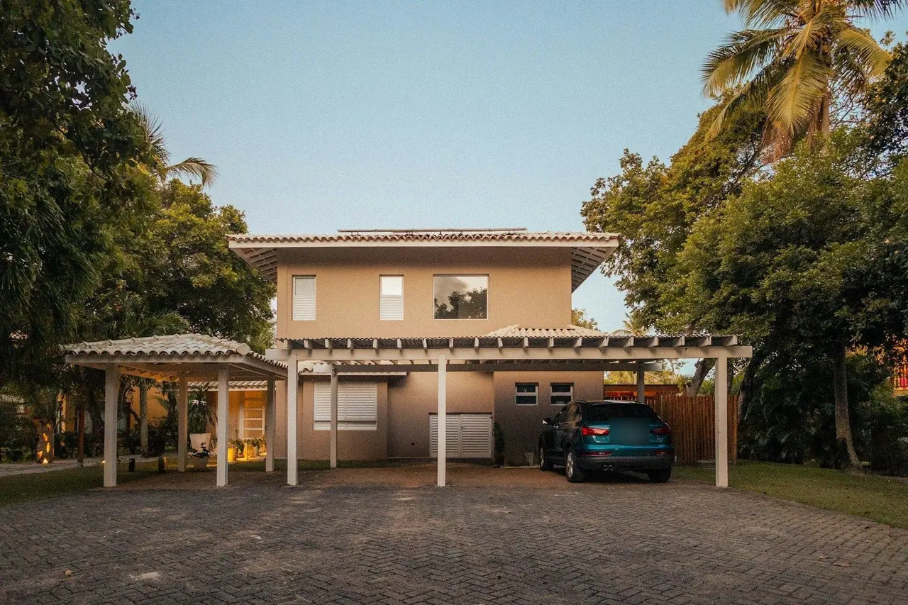 Casa de dois andares com carro estacionado na garagem coberta