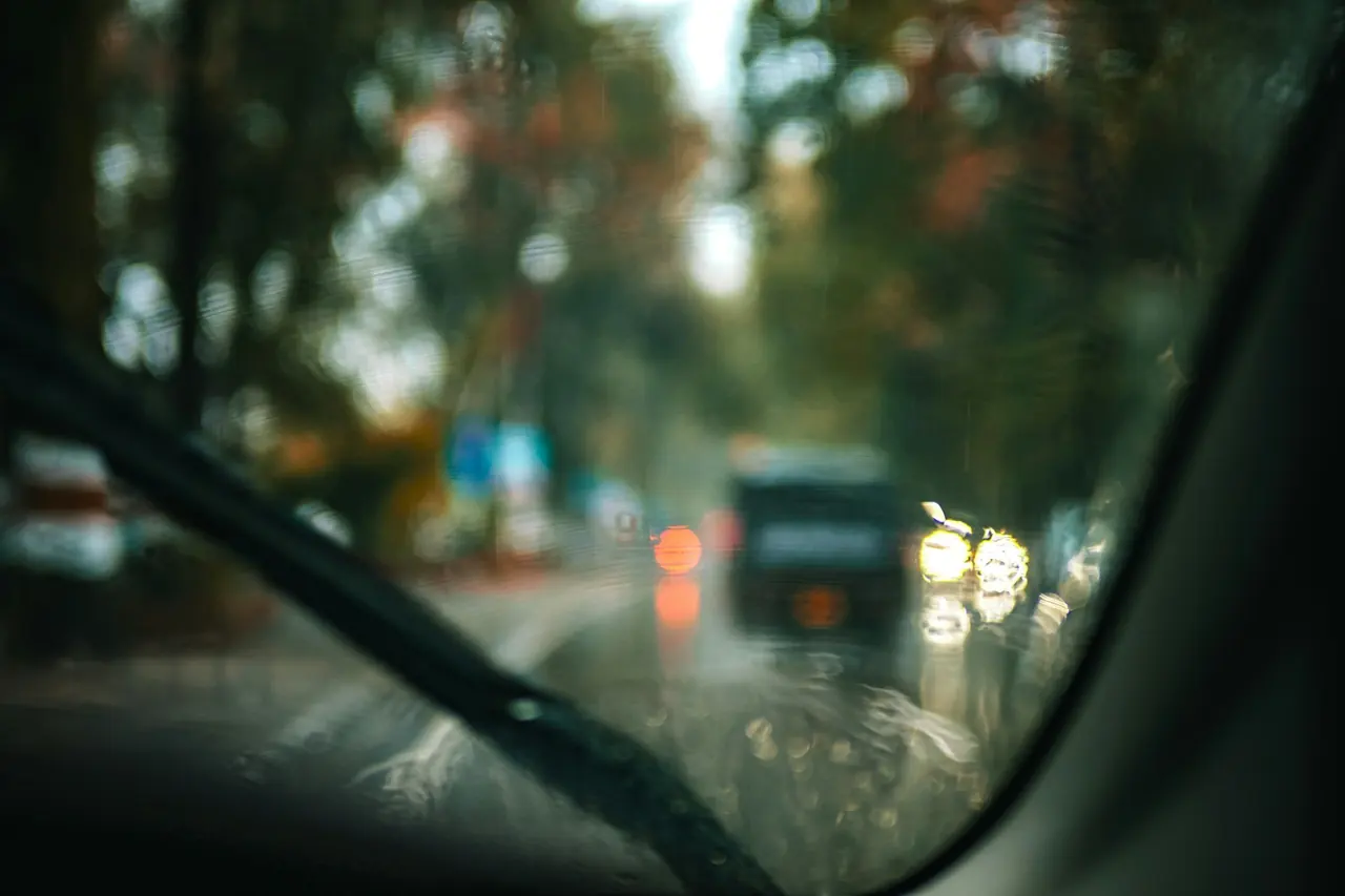 Vista de uma rua através do para-brisa molhado de chuva