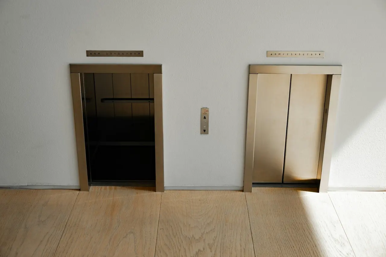 Portas de elevador em um hall claro de prédio residencial