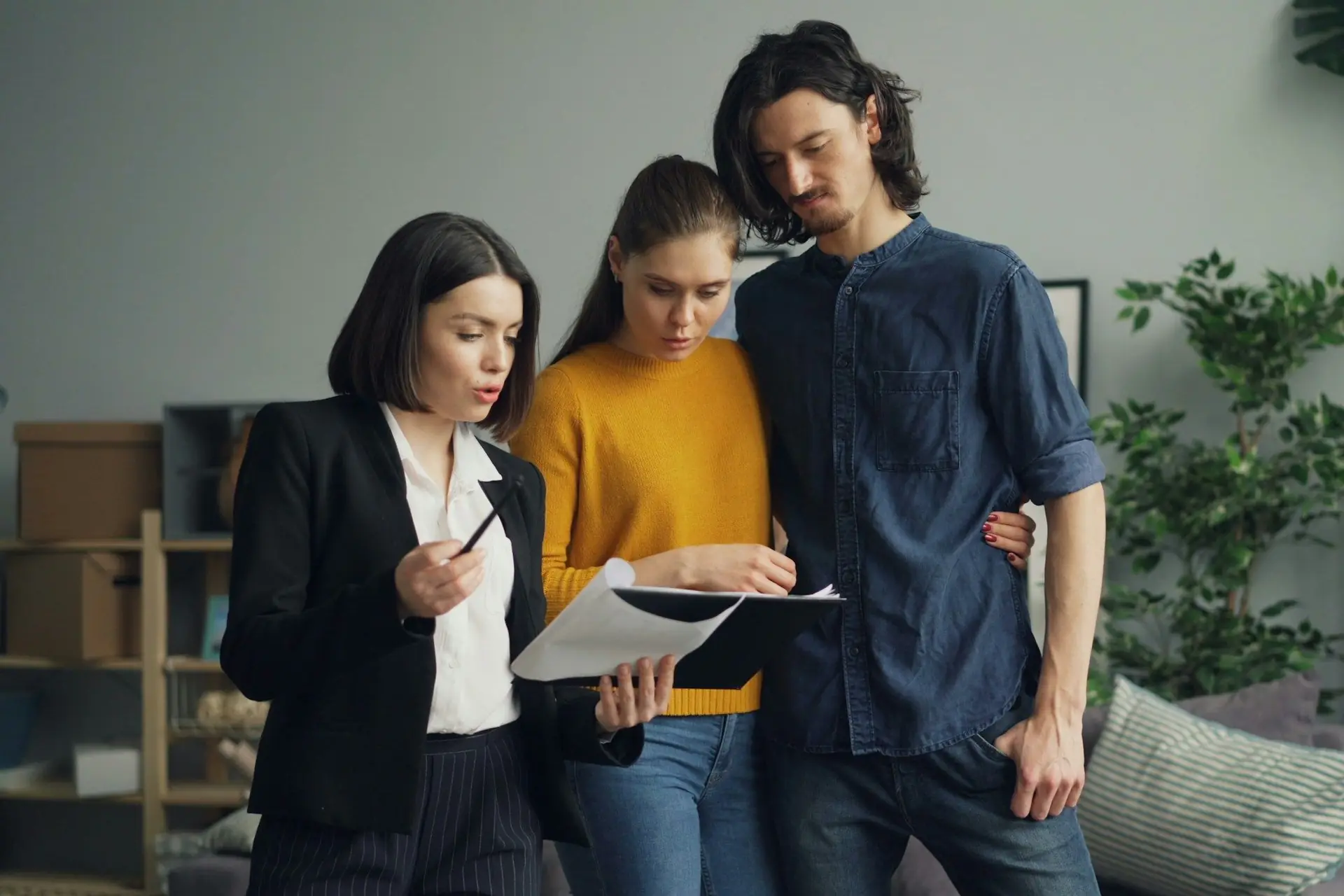 Consultora explicando um documento a um casal em uma sala de estar